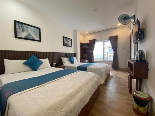 a hotel room with two beds and a window at Hoàng Hưng Hotel in Quy Nhon