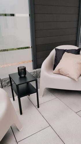 a patio with a white couch and a black table at Ferienwohnung Frieda, Merzig in Merzig