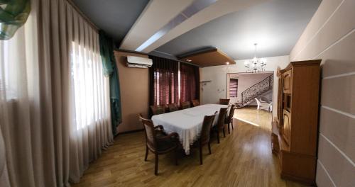 塔什坎的住宿－Garda，一间配备有白色桌椅的用餐室