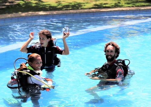 three people in the water in a swimming pool at Island View Beachfront Resort in Anda