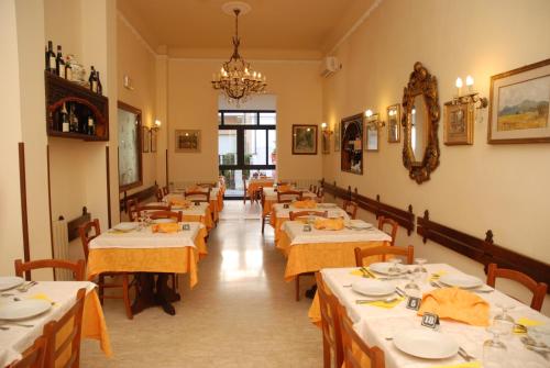 a dining room with tables with yellow tablecloths at Hotel Caribe in Viareggio