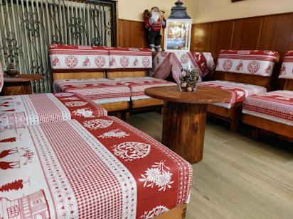 a room with red and white blankets and tables at Albergo Neni in Brentonico