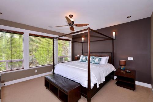 1 dormitorio con cama con dosel y ventilador de techo en Nature's Gate Executive Estate, en Victoria
