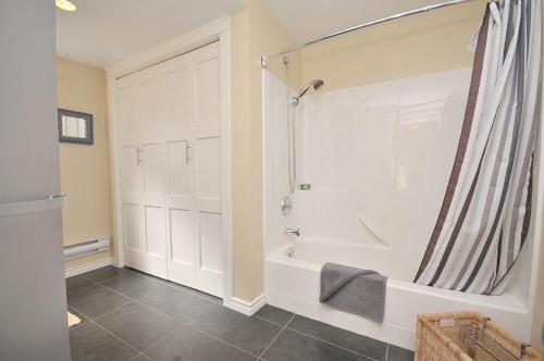 a bathroom with a shower and a bath tub at Heron View Cottage in Sidney