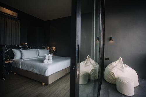 a bedroom with a bed with two stuffed animals on it at INN BLOG HOTEL Pakbara in Satun