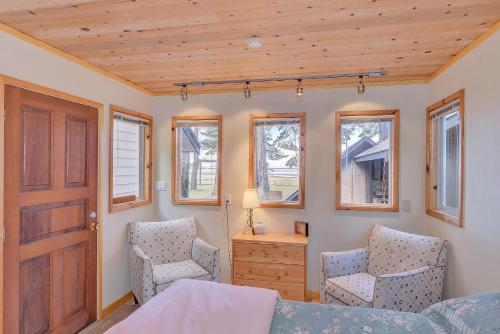 a bedroom with a bed and two chairs and a door at Kye Bay Beach House in Comox