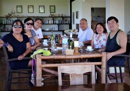a group of people sitting around a wooden table at Island View Beachfront Resort in Anda