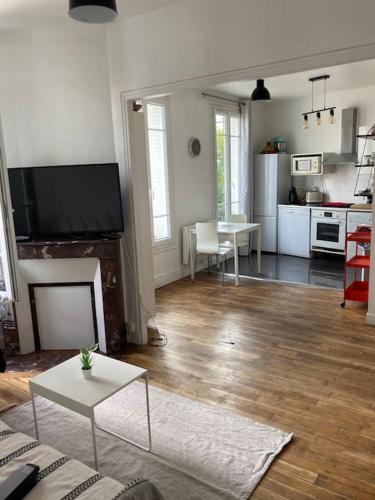 a living room with a fireplace and a kitchen at Bel Appartement lumineux à 2 min du RER B in La Courneuve