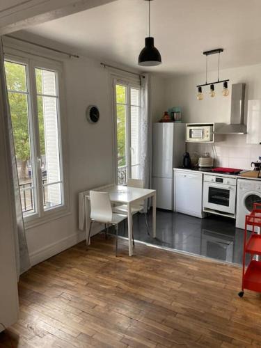 a kitchen with a table and a kitchen with a stove at Bel Appartement lumineux à 2 min du RER B in La Courneuve