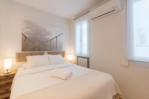 Un dormitorio blanco con una gran cama blanca y una ventana en Fee4Me Vallés 6, en Madrid