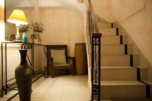 een woonkamer met een trap en een vaas bij Frangipani Penthouse in New Delhi