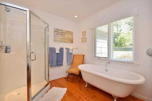 a white bathroom with a tub and a shower at Pendray House in North Saanich