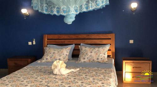 a bedroom with a bed with a blue wall at Nosy Bay View in Nosy Be