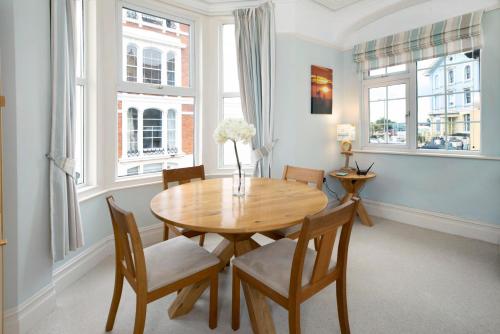 a dining room with a wooden table and chairs at Seaview at No. 26 Northumberland Place in Teignmouth