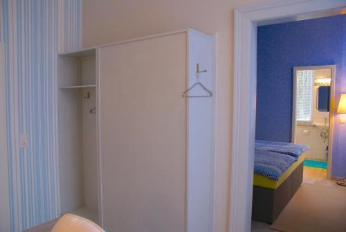 a bedroom with a white closet and a bed at Hotel Elfenberg in Schieder-Schwalenberg