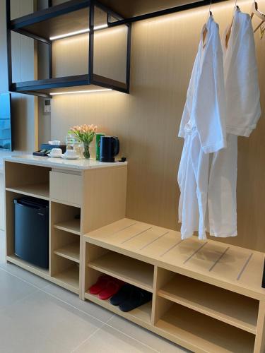 a closet with white clothes hanging from a wall at The Arena Seaview Cam Ranh Home in Cam Ranh