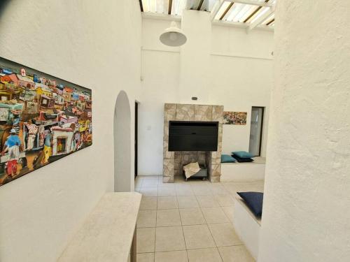 ein Wohnzimmer mit einem TV und einem Gemälde an der Wand in der Unterkunft Angel's Rest in Port Alfred
