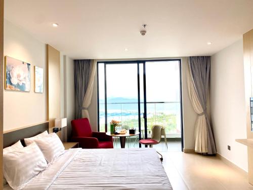 a bedroom with a bed and a table with a chair at The Arena Seaview Cam Ranh Home in Cam Ranh