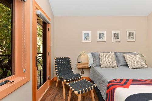 1 dormitorio con 1 cama y 2 sillas en Salishan Tree House Suite en Cowichan Bay