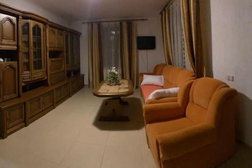 a living room with a couch and a table at Vila primitoare in apropiere de aeroport in Ghiroda