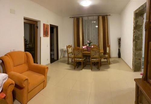 a living room with a table and chairs at Vila primitoare in apropiere de aeroport in Ghiroda
