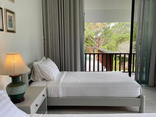 a hotel room with two beds and a balcony at Monlada Khaoyai in Mu Si