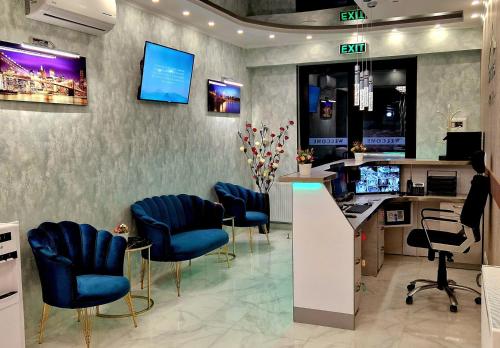 un salon avec des chaises bleues et une réception dans l'établissement Sierra Hotel Tbilisi, à Tbilissi