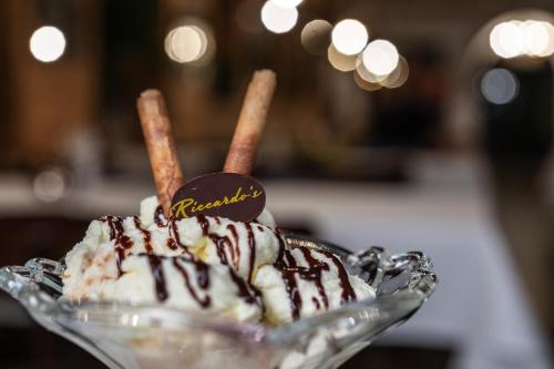 a ice cream sundae with chocolate sauce and cinnamon sticks at Hotel Cervo in Sils Maria