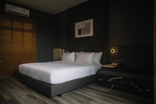 a bedroom with a white bed and a telephone at INN BLOG HOTEL Pakbara in Satun