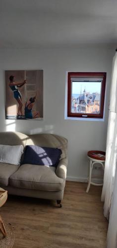 a living room with a couch and a picture on the wall at Escapade de charme les pieds dans l'eau in Houlgate