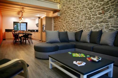 a living room with a couch and a table at Loft Chocolatine, spacieux, piscine, trampoline in Carcassonne