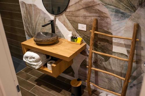 uma casa de banho com uma mesa de madeira e um espelho em MareLuna Rooms em Nápoles
