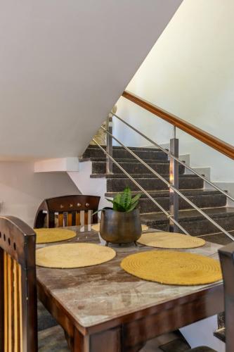 a dining room with a table and a staircase at VILLA ZORBA - 4BHK Villa in Candolim in Old Goa