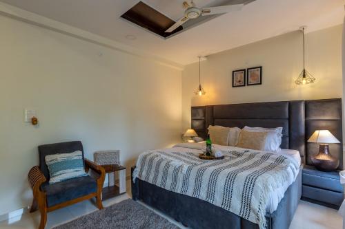 a bedroom with a large bed and a chair at VILLA ZORBA - 4BHK Villa in Candolim in Old Goa