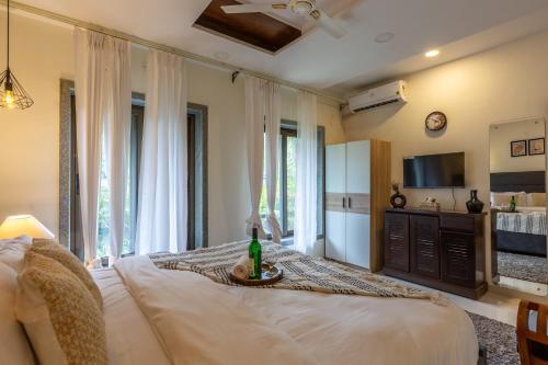 a bedroom with a bed with a bottle of wine on it at VILLA ZORBA - 4BHK Villa in Candolim in Old Goa