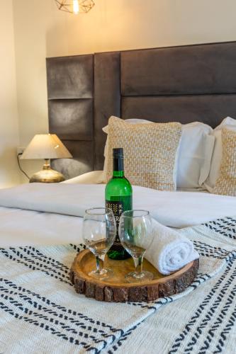 a tray with a bottle and two wine glasses on a bed at VILLA ZORBA - 4BHK Villa in Candolim in Old Goa