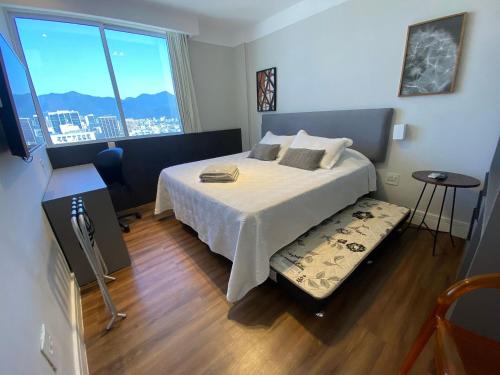 1 dormitorio con cama y ventana grande en Duas suítes com vista deslumbrante em Ipanema, en Río de Janeiro
