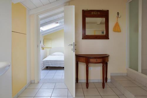 a room with a table and a bed with a mirror at Villa Amelia Rooms in Marina di Pietrasanta
