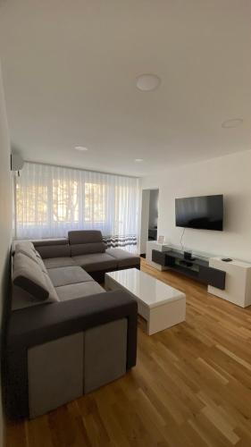 sala de estar con sofá y TV de pantalla plana en M.B.A. APARTMENTS en Karlovac