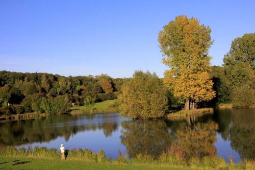 a man standing in front of a lake at Hessen Hotelpark Hohenroda in Hohenroda