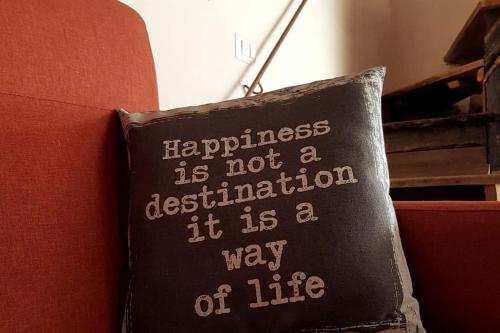 a pillow on a couch with the words happiness is not a destination at *La Torre Di Amelia* Nel Cuore Dell' Umbria in Amelia