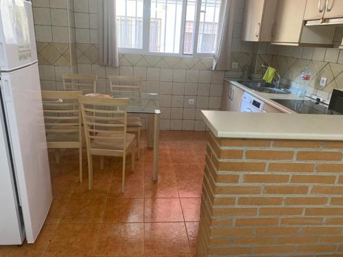 a kitchen with a table and chairs and a refrigerator at Apartamento Talavera in Talavera de la Reina
