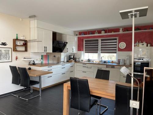 a kitchen with a wooden table and black chairs at Ferienhaus Willmann in Böhme