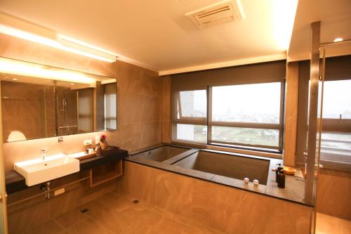 baño con lavabo y ventana grande en 晨曦溫泉宅 en Toucheng