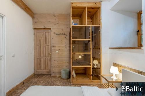 a room with a wooden wall and a book shelf at St Anne studio in Vilnius