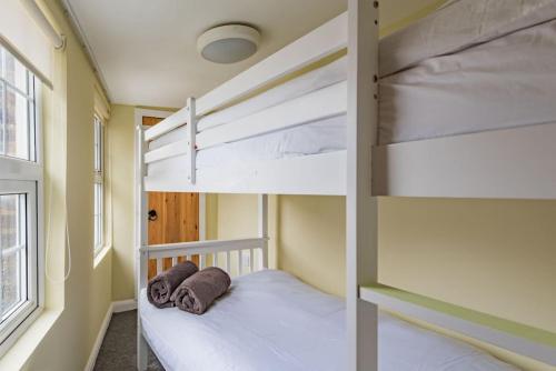 a bunk bed in a room with two bunk beds at Curious Cottage in Deal
