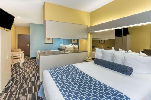 a hotel room with a large bed and a kitchen at Microtel Inn & Suites by Wyndham Stockbridge/Atlanta I-75 in Stockbridge