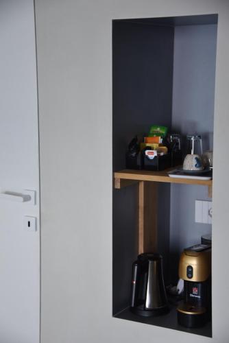 a kitchen shelf with a coffee maker on it at Giuggiulena in Siracusa