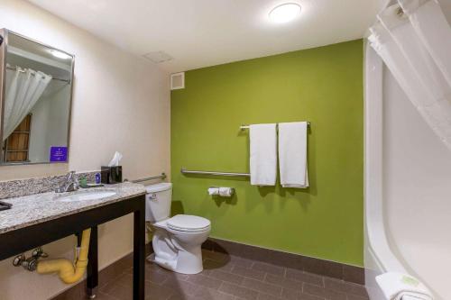 bagno con servizi igienici e parete verde di Sleep Inn Ontario a Ontario