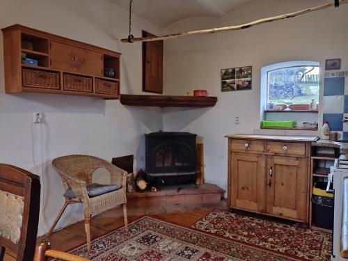 a kitchen with a fireplace and a chair and a stove at Holiday Home U Černých Ovcí in Náměšť nad Oslavou